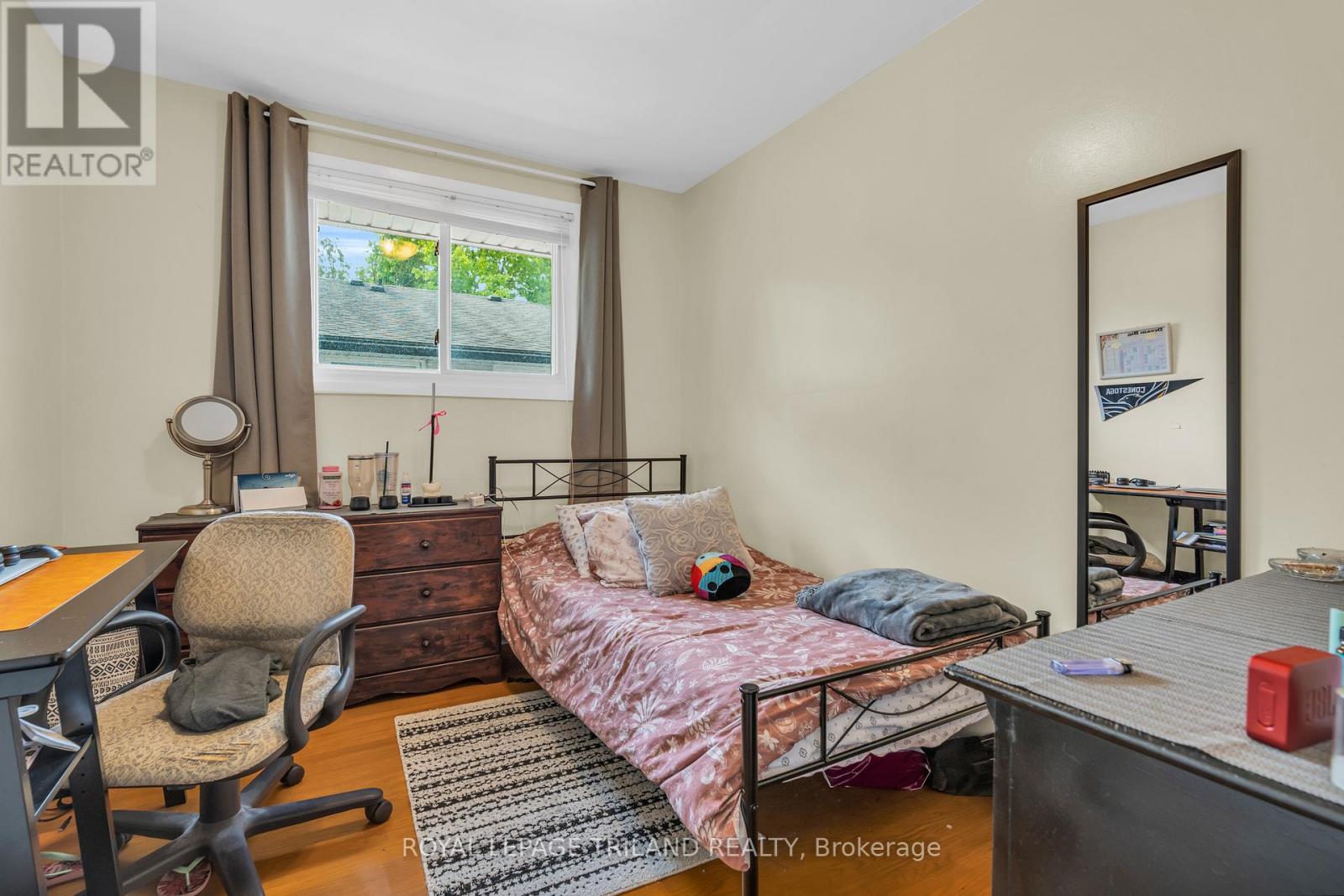 A bedroom with a bed, desk, and chair.