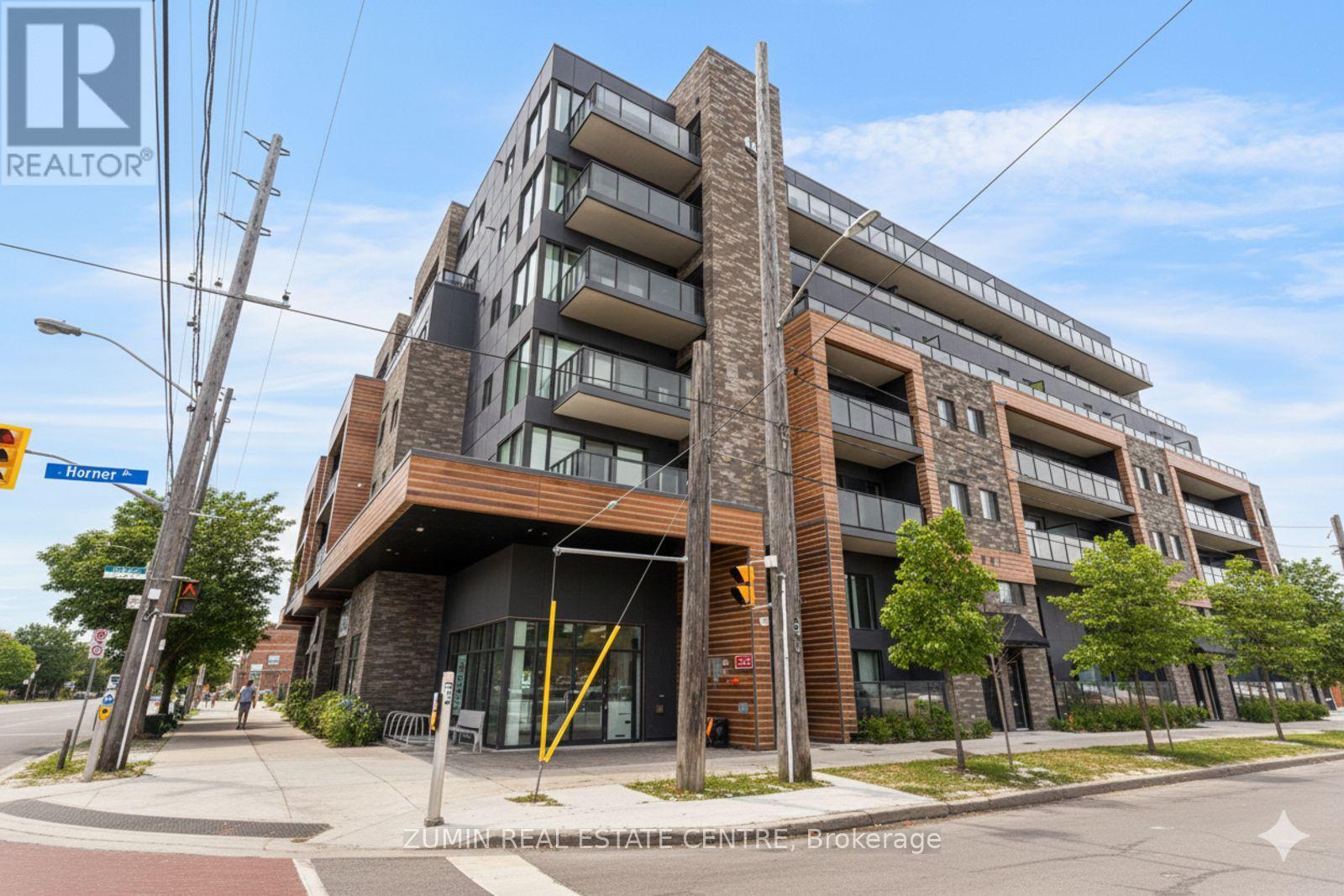 A modern apartment building with a brick facade and multiple balconies.