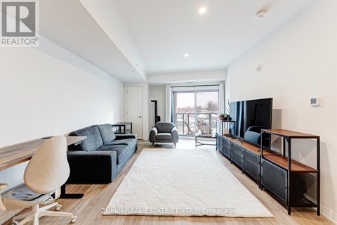 A modern living room with a black couch and a television.