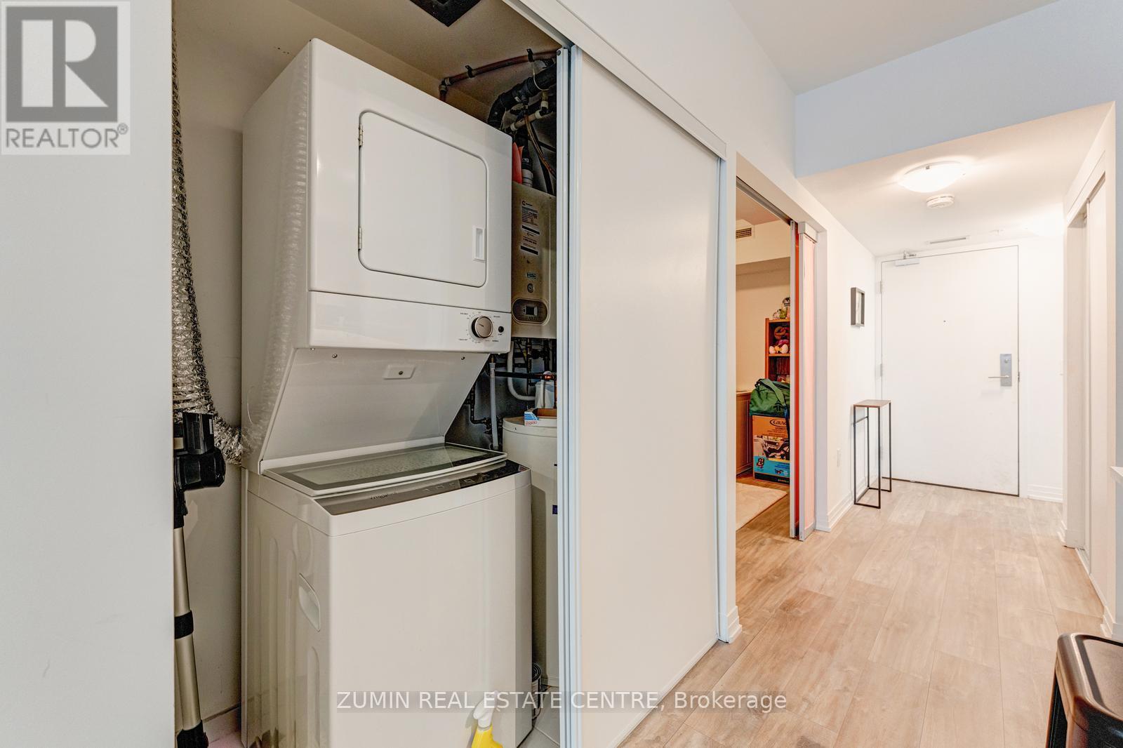 A white refrigerator is in a small kitchen with a door open.