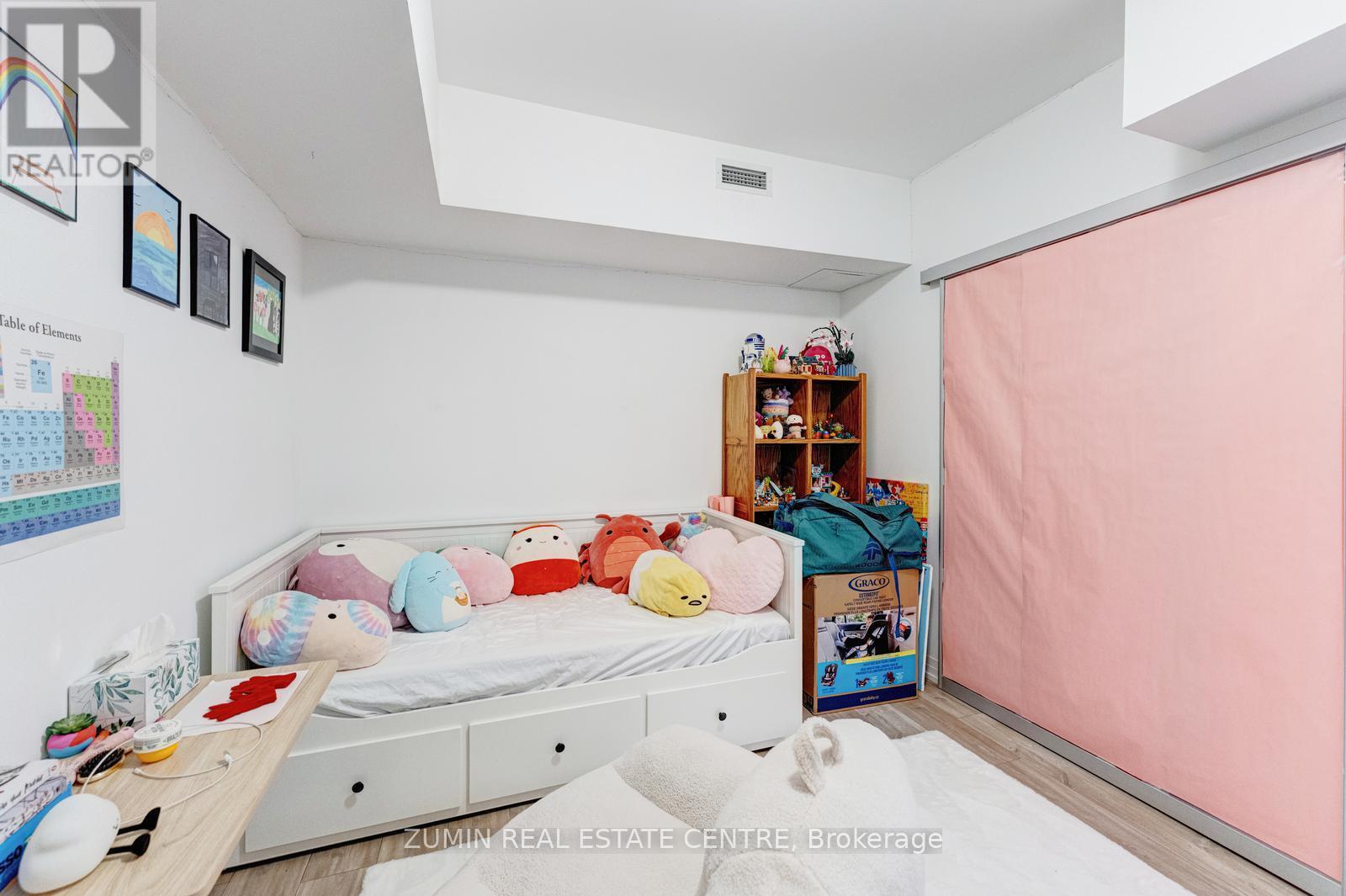 A child's bedroom with a bed, toys, and a calendar on the wall.