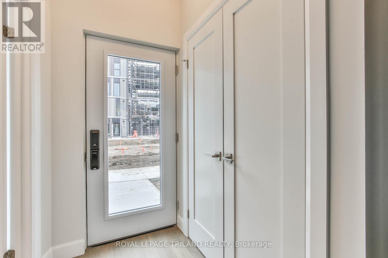 A white door with a window showing a construction site.