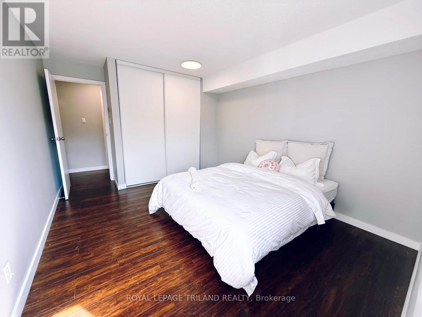 A bedroom with a bed, dresser, and wardrobe.
