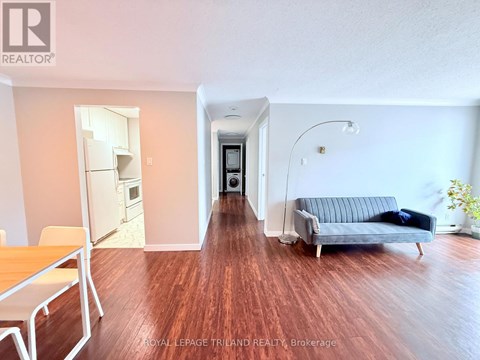 A living room with a grey couch and a wooden floor.