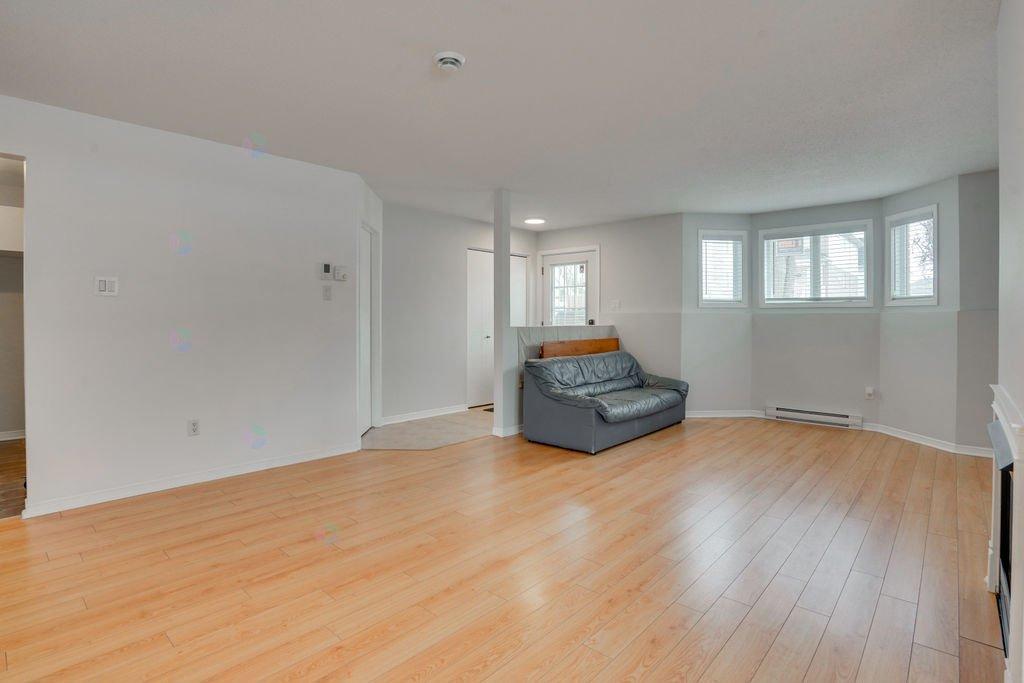 A living room with a grey couch and wooden floors.