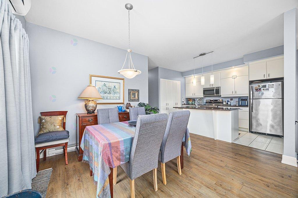 A kitchen with a table and chairs in the foreground and a refrigerator in the background.