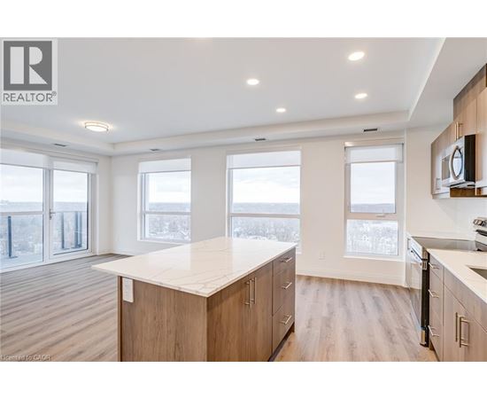 A well-lit kitchen with wooden cabinets and a large island.