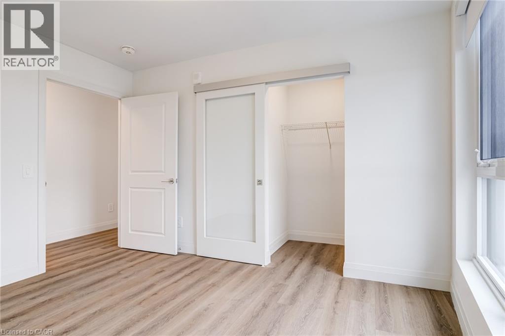 A white bedroom with a sliding door and a window.
