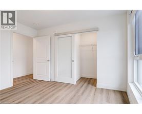 A white bedroom with a sliding door and a window.