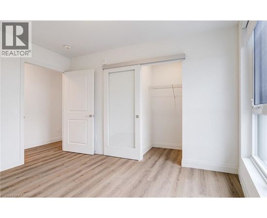 A white bedroom with a sliding door and a window.
