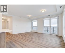 A spacious room with wooden flooring and large windows.