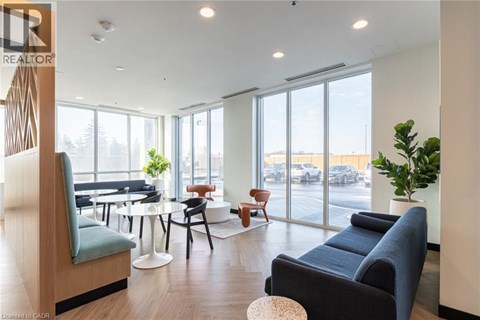 A living room with a blue couch and a wooden chair.