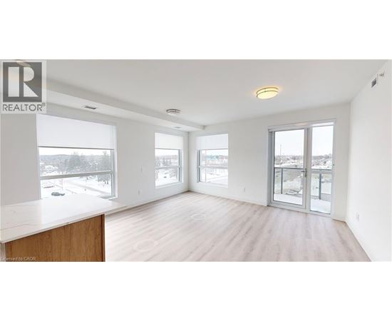 A spacious room with a large window and sliding glass doors.