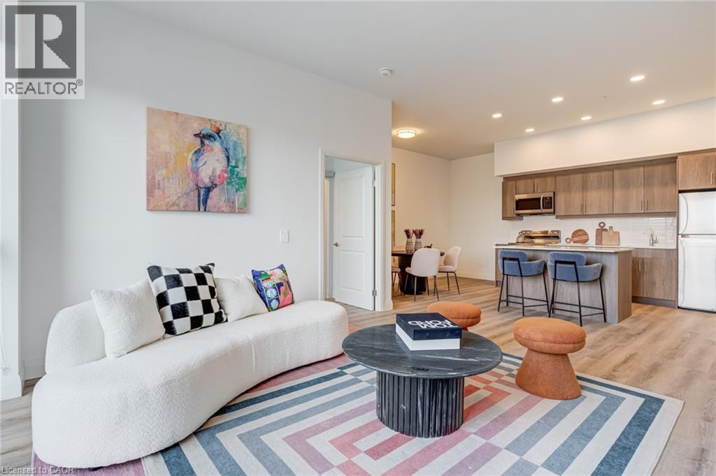 A living room with a white couch and a painting on the wall.