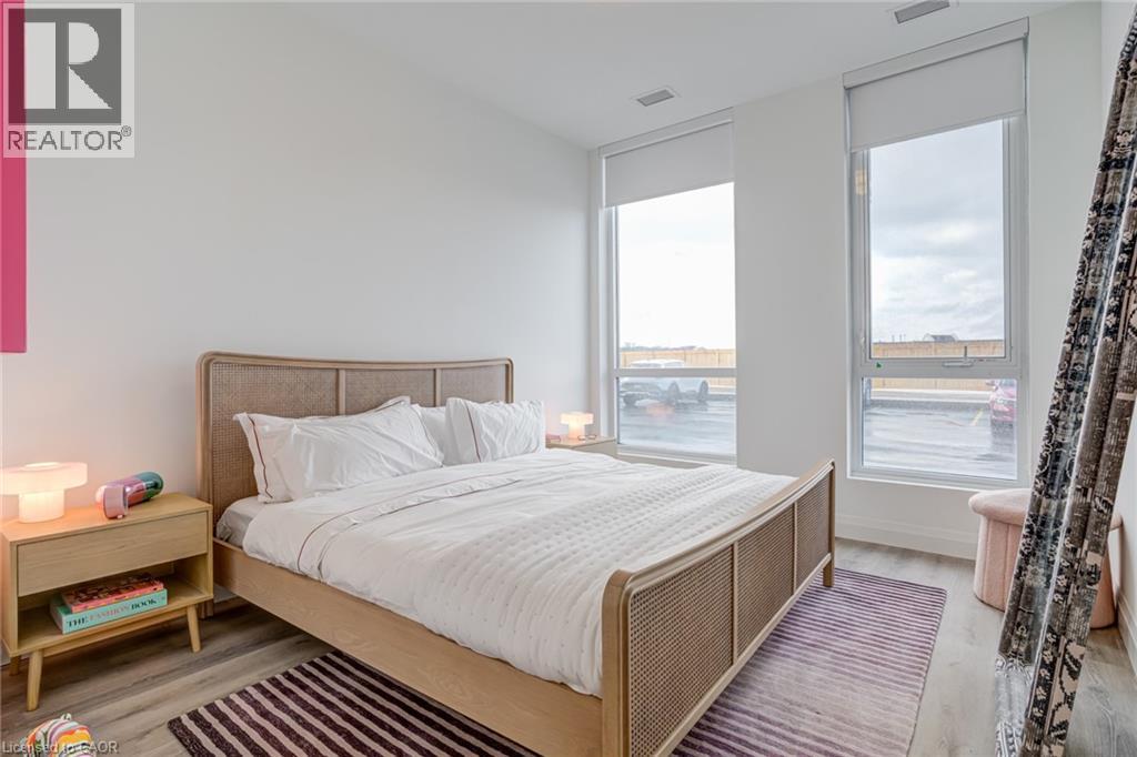 A bedroom with a large bed and a window overlooking a parking lot.