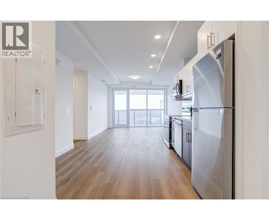 A modern kitchen with a refrigerator on the right side.