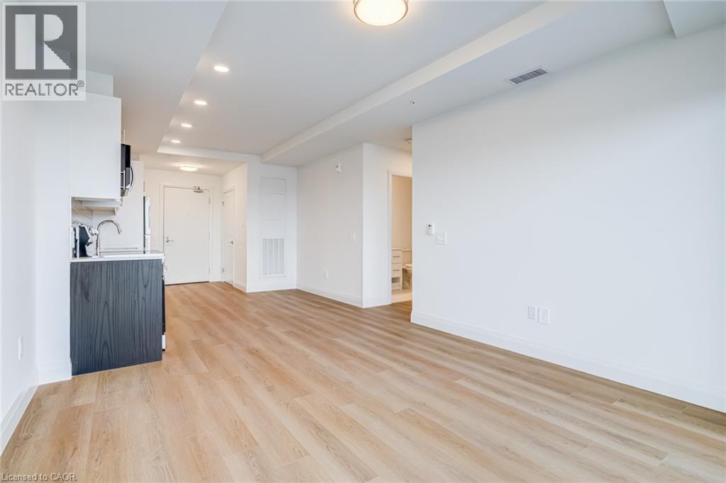 A spacious room with wooden flooring and white walls.