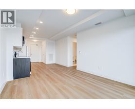 A spacious room with wooden flooring and white walls.