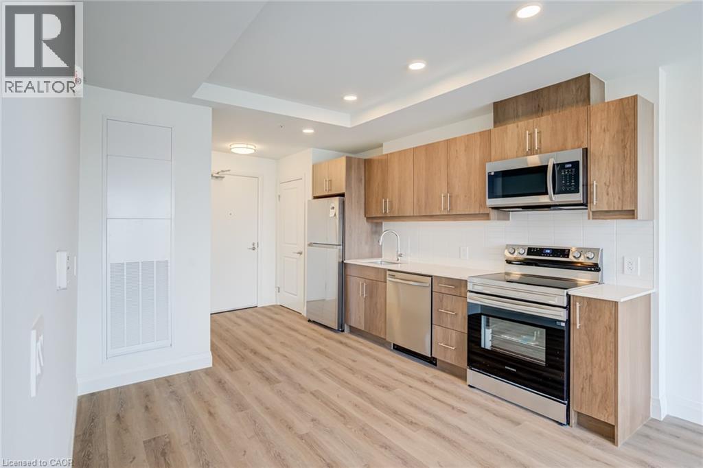 A modern kitchen with wooden cabinets and stainless steel appliances.