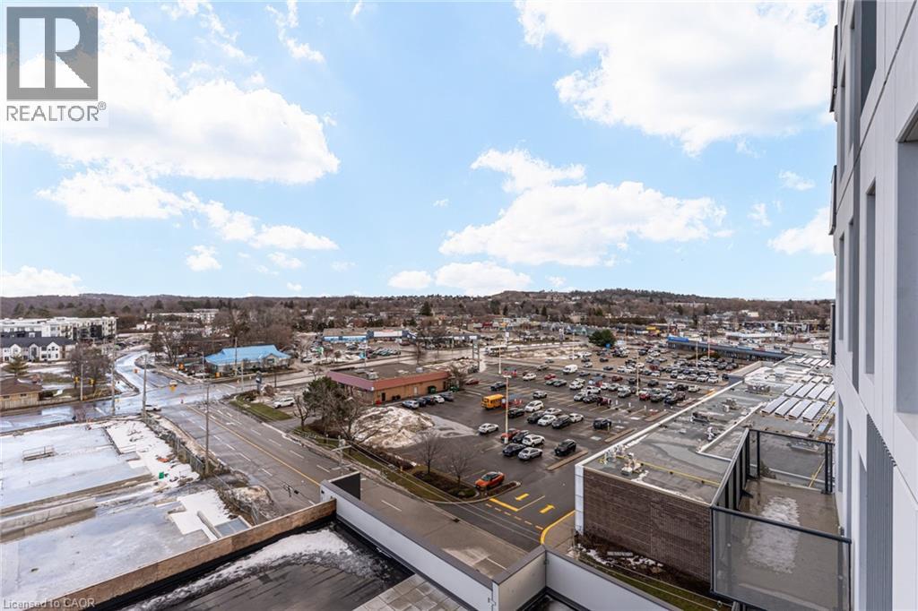 A parking lot with a building in the background and a blue sky with clouds.