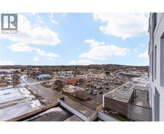 A parking lot with a building in the background and a blue sky with clouds.