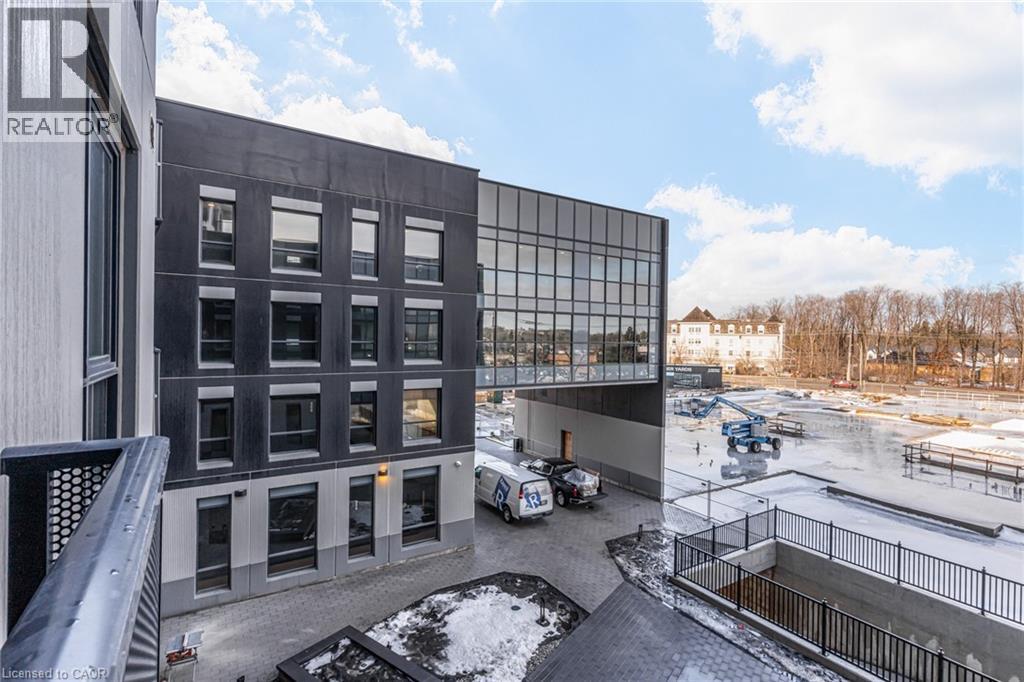 A modern building with a glass facade and a parking lot in front.