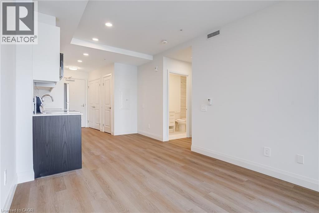 A spacious room with wooden flooring and white walls.