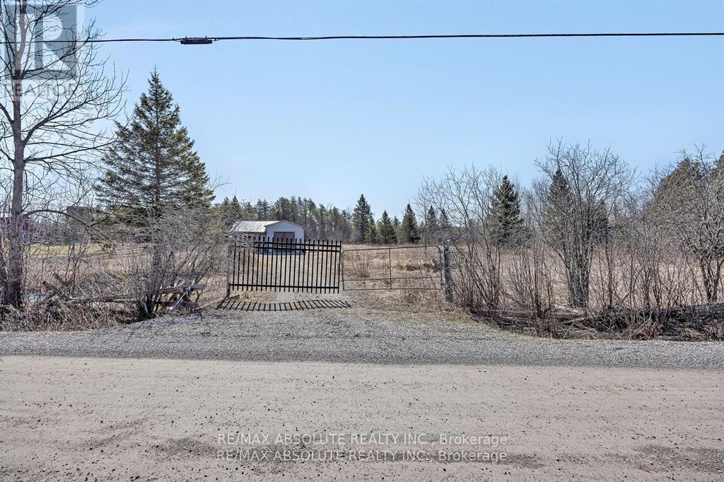 A barren landscape with a fence and a building in the distance.