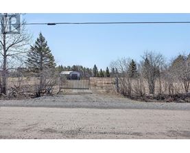 A barren landscape with a fence and a building in the distance.