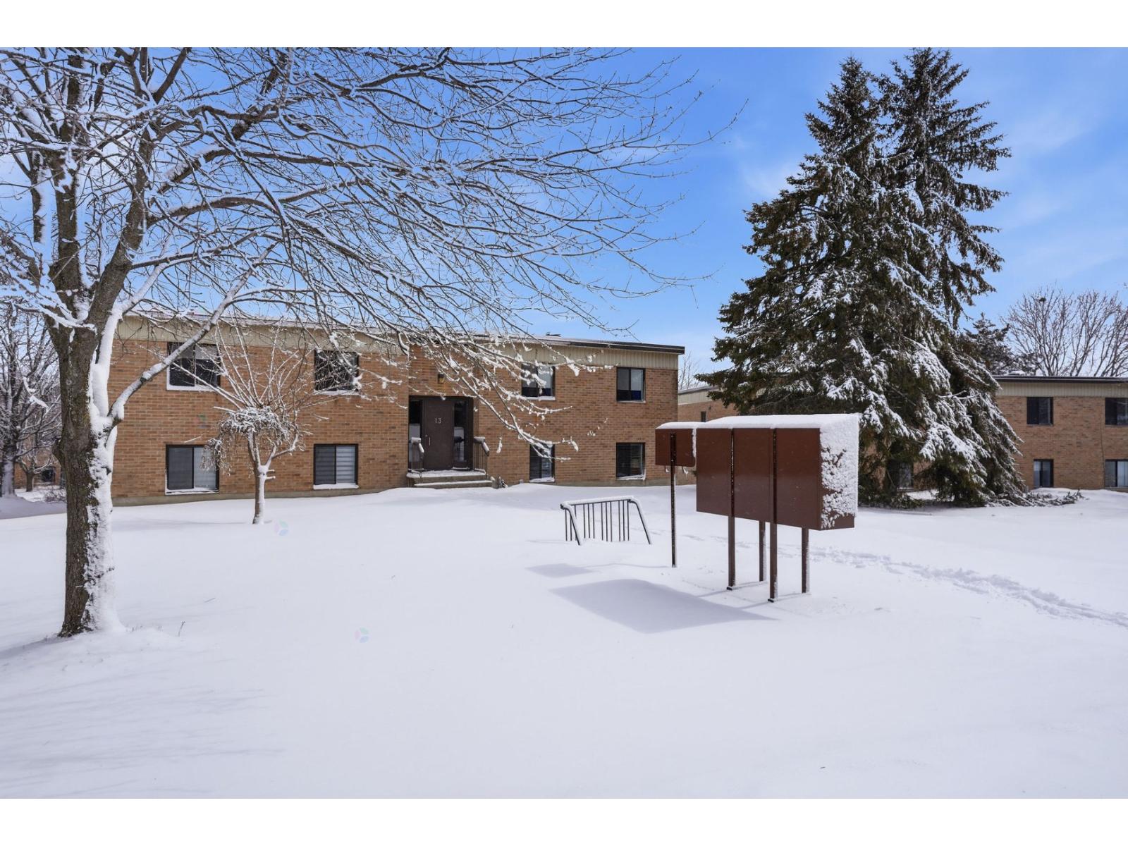 A snowy landscape with a building and trees.