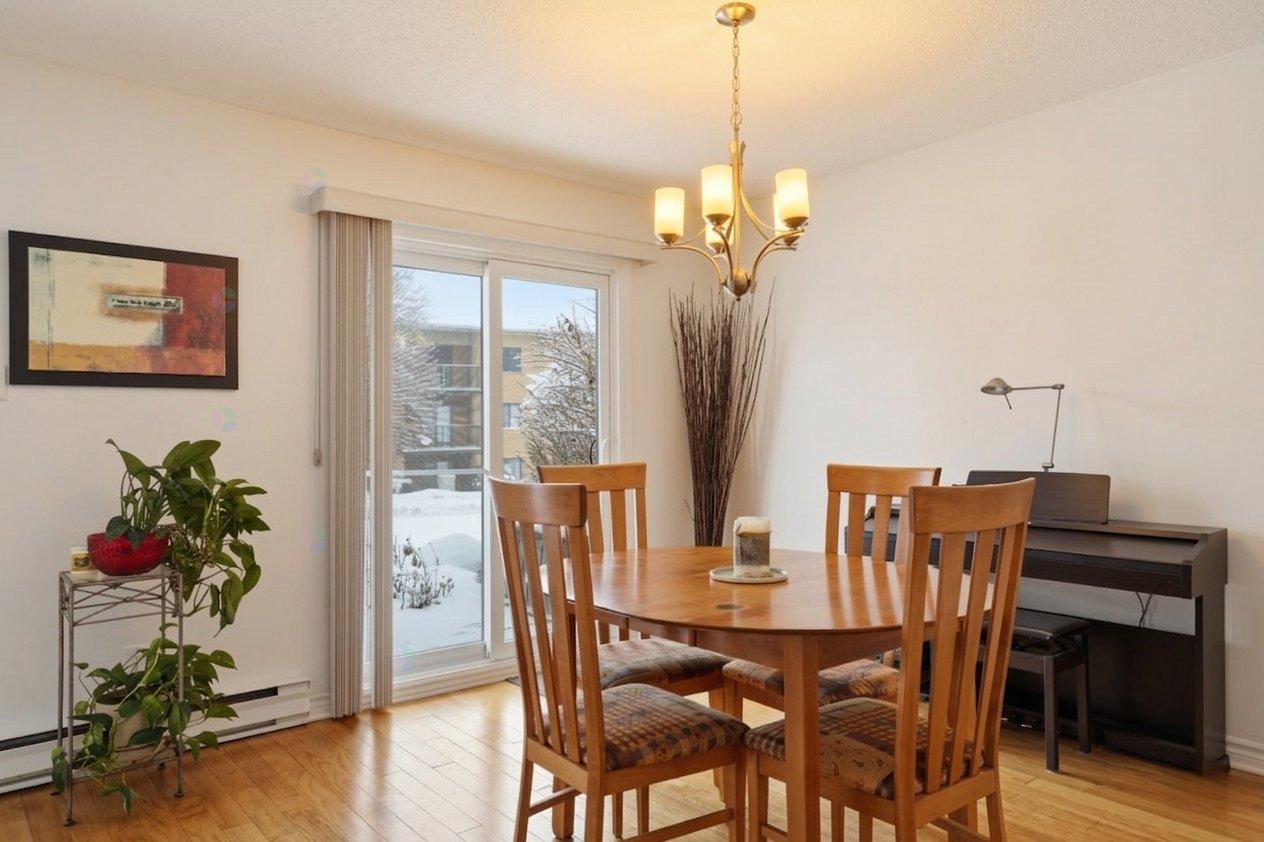 A dining room with a wooden table and chairs.