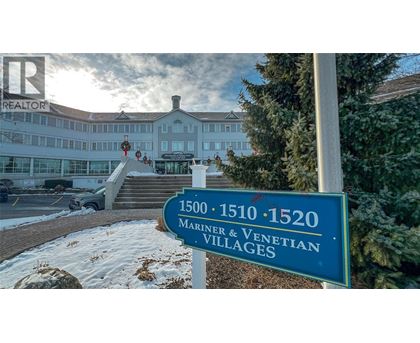 A sign for the 1500-1520 Mariner & Venetian Villages stands in front of a building.