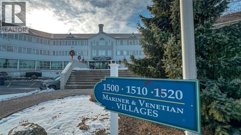A sign for the 1500-1520 Mariner & Venetian Villages stands in front of a building.