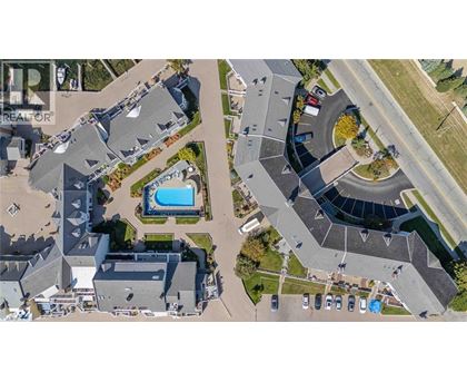 A bird's eye view of a residential area with houses, roads, and a swimming pool.