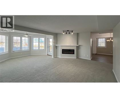 A living room with a fireplace and a large window.