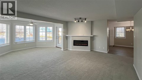 A living room with a fireplace and a large window.