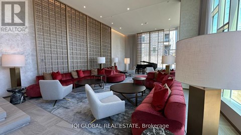A living room with a red couch and a white chair.