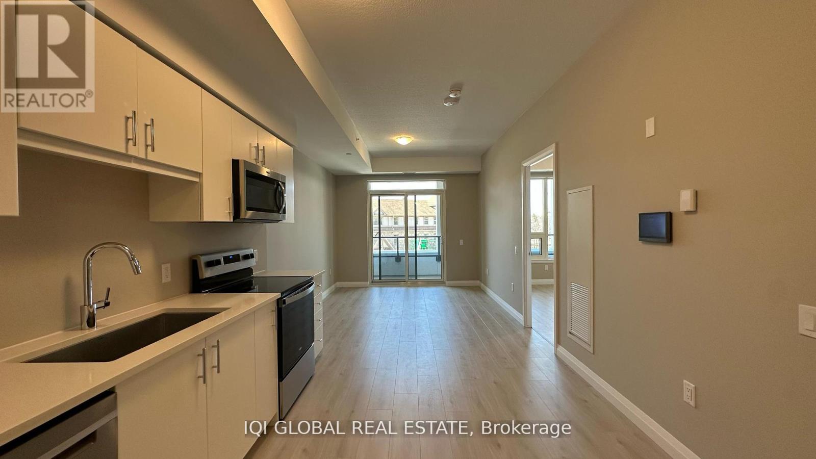 A spacious kitchen with white cabinets and a black stove top oven.