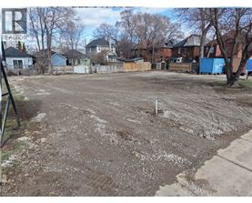 A dirt field with a white pole in the middle.