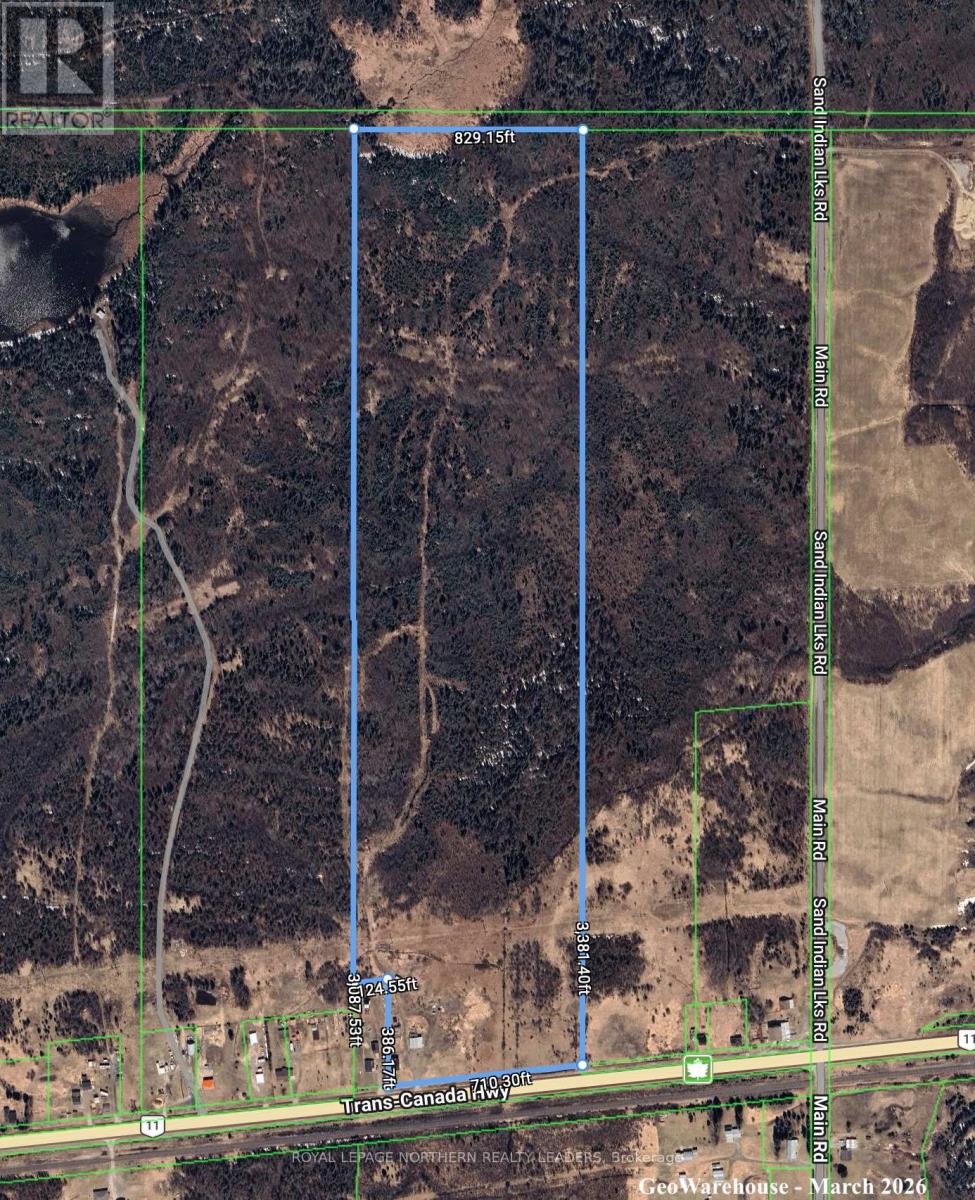 A satellite image shows a large open area with a road running through it and a green border around it.