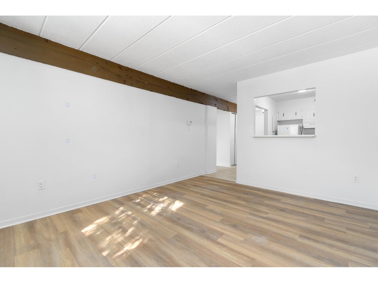 A room with wooden flooring and white walls.
