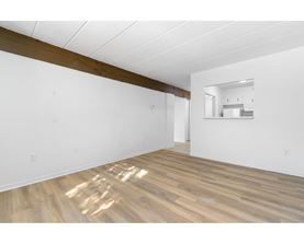 A room with wooden flooring and white walls.