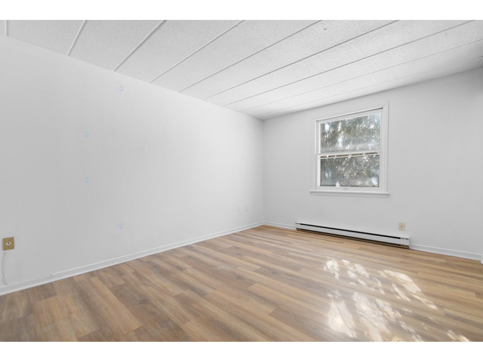 A room with a window and a radiator on the wall.