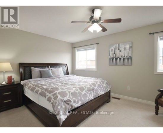 A bedroom with a large bed and a ceiling fan.