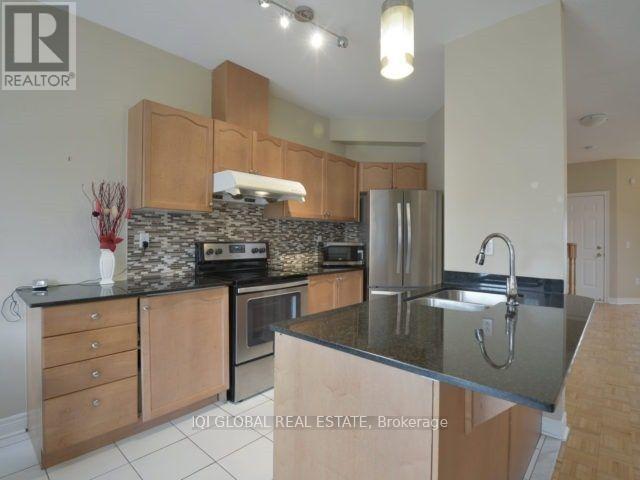 A kitchen with wooden cabinets and a stone backsplash.