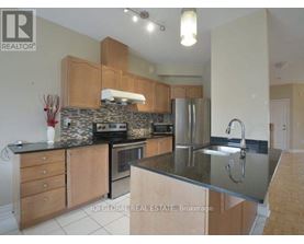 A kitchen with wooden cabinets and a stone backsplash.