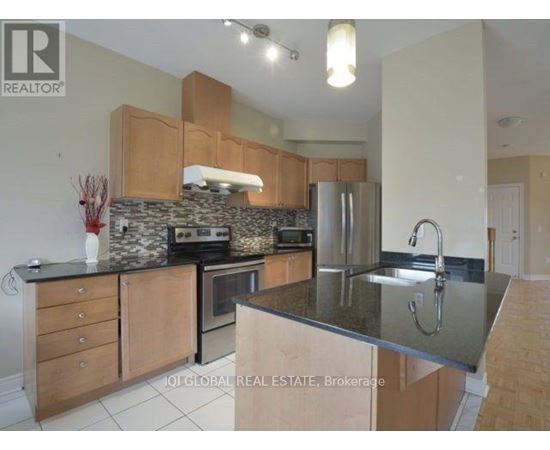 A kitchen with wooden cabinets and a stone backsplash.
