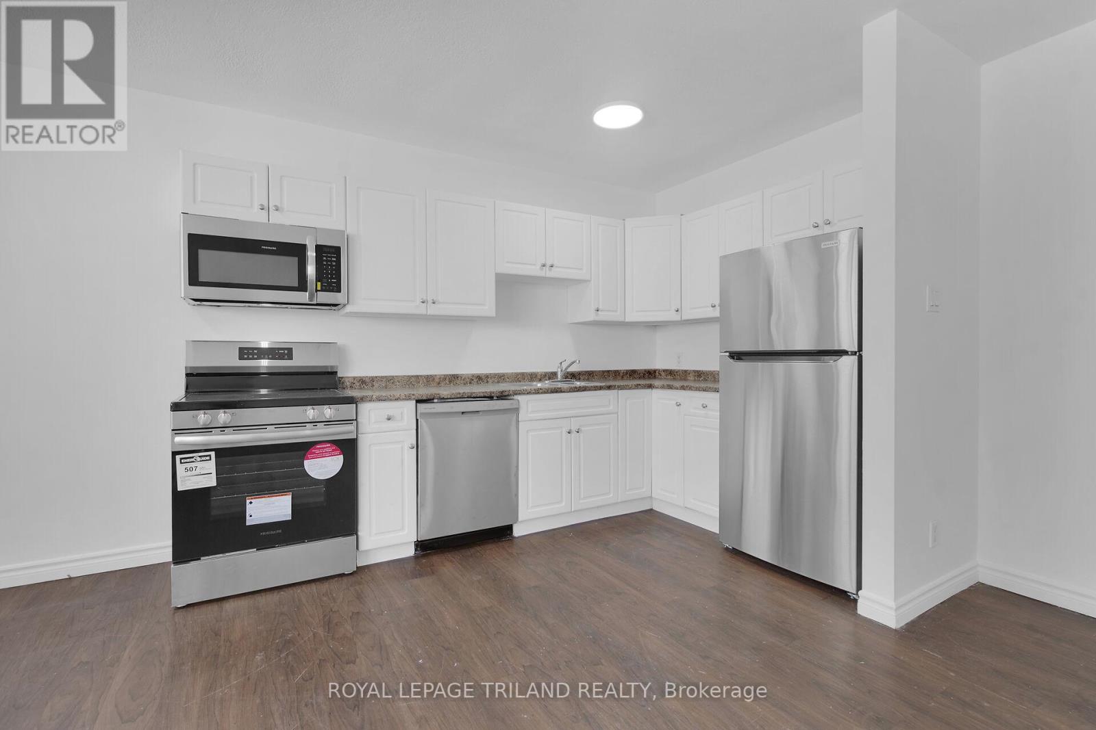 A kitchen with white cabinets and stainless steel appliances.