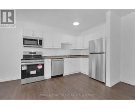 A kitchen with white cabinets and stainless steel appliances.