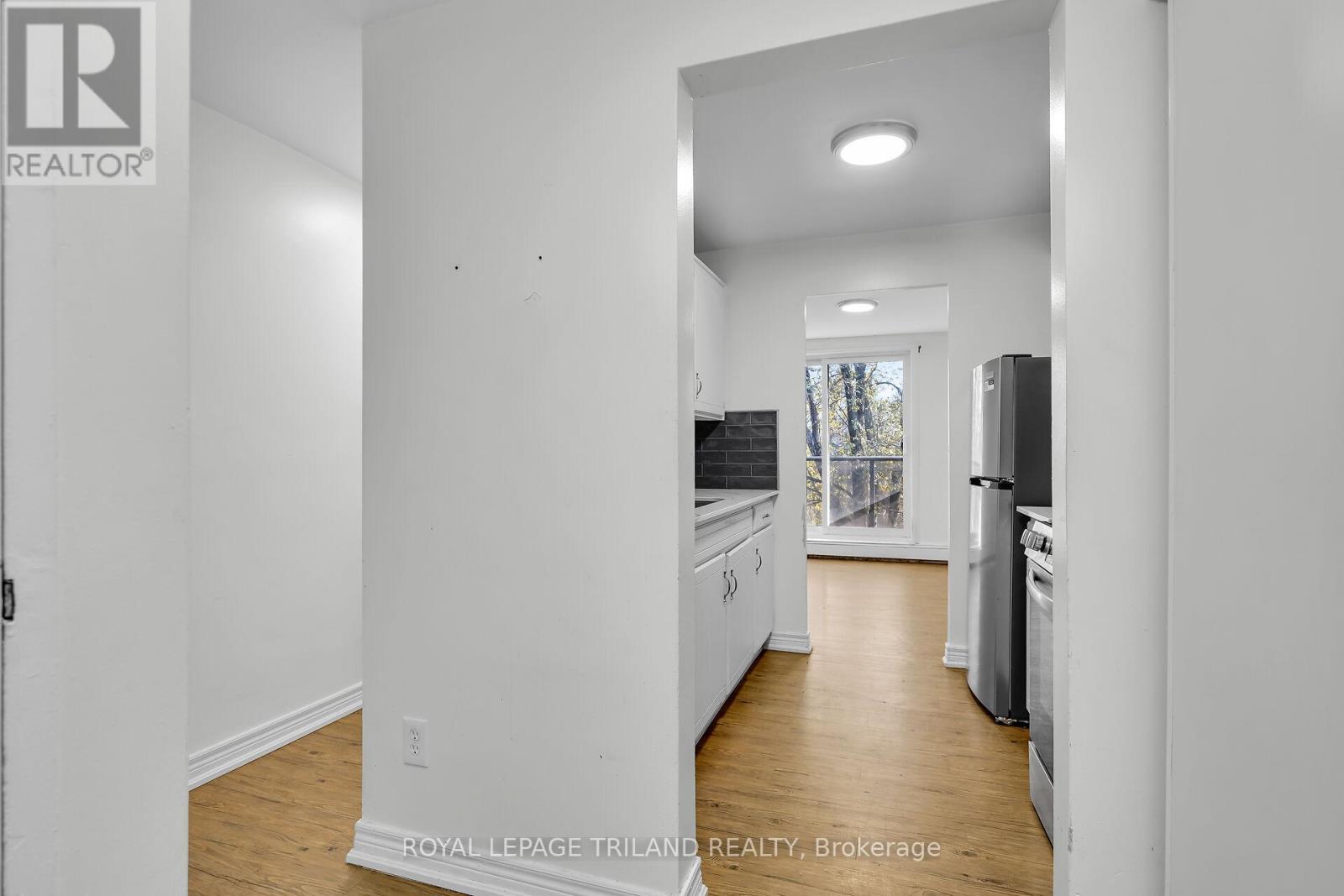 A white kitchen with a refrigerator, stove, and dishwasher.